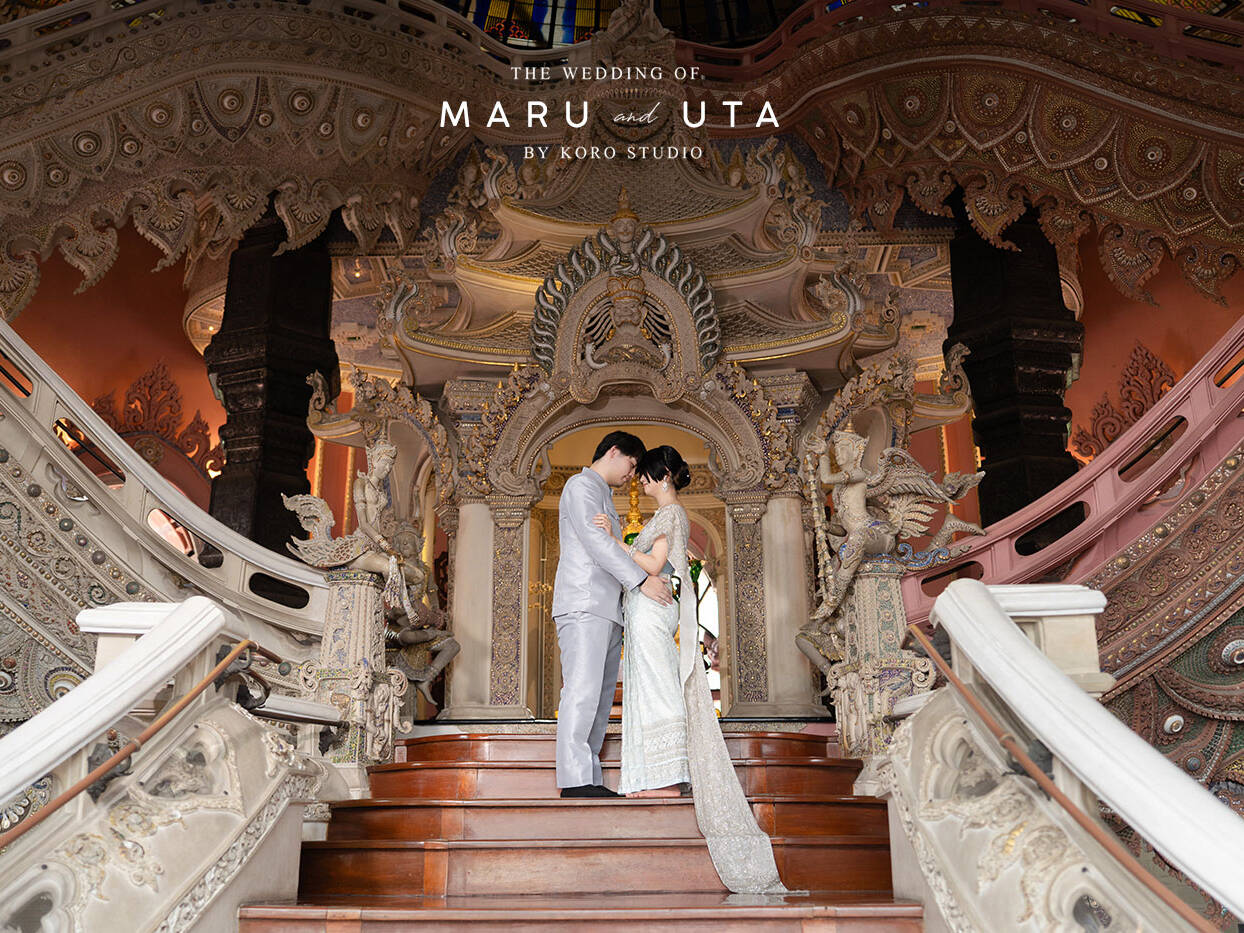 a man and woman standing on stairs in front of ornate staircase